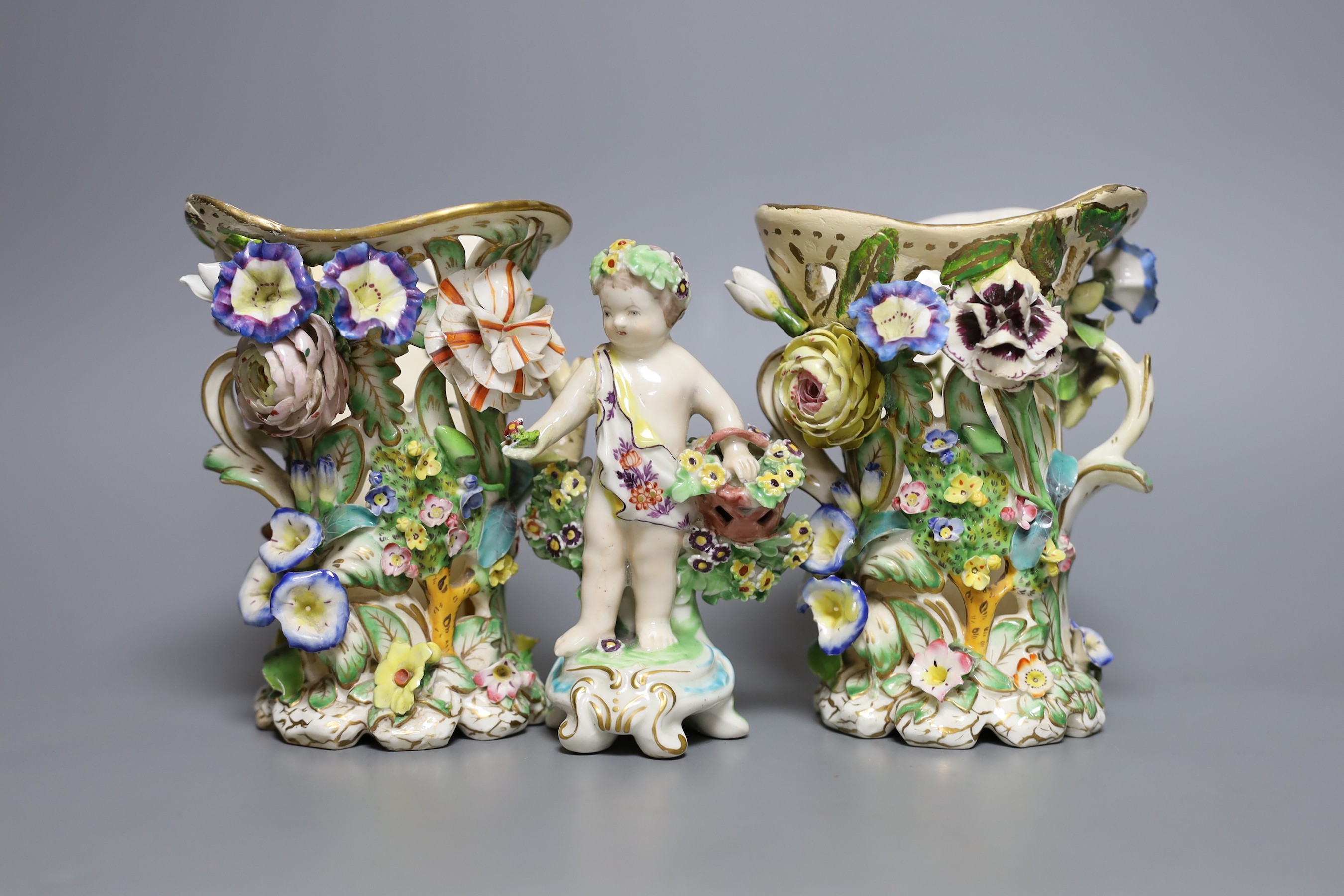 A 19th century Derby figure of a putti with flowers together with two floral encrusted porcelain vases, tallest 14cm